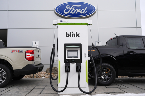 Electric vehicle chargers sit outside a Ford dealership.