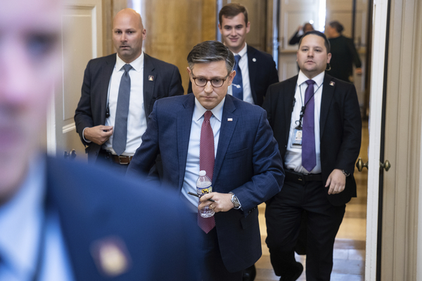 House Speaker Mike Johnson is flanked by his security detail as he enters the U.S. Capitol.