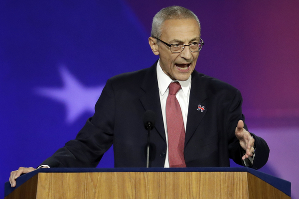 John Podesta gestures on stage. 
