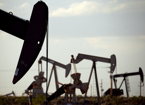 Pump jacks work in a field near Lovington, N.M., in April 2015.